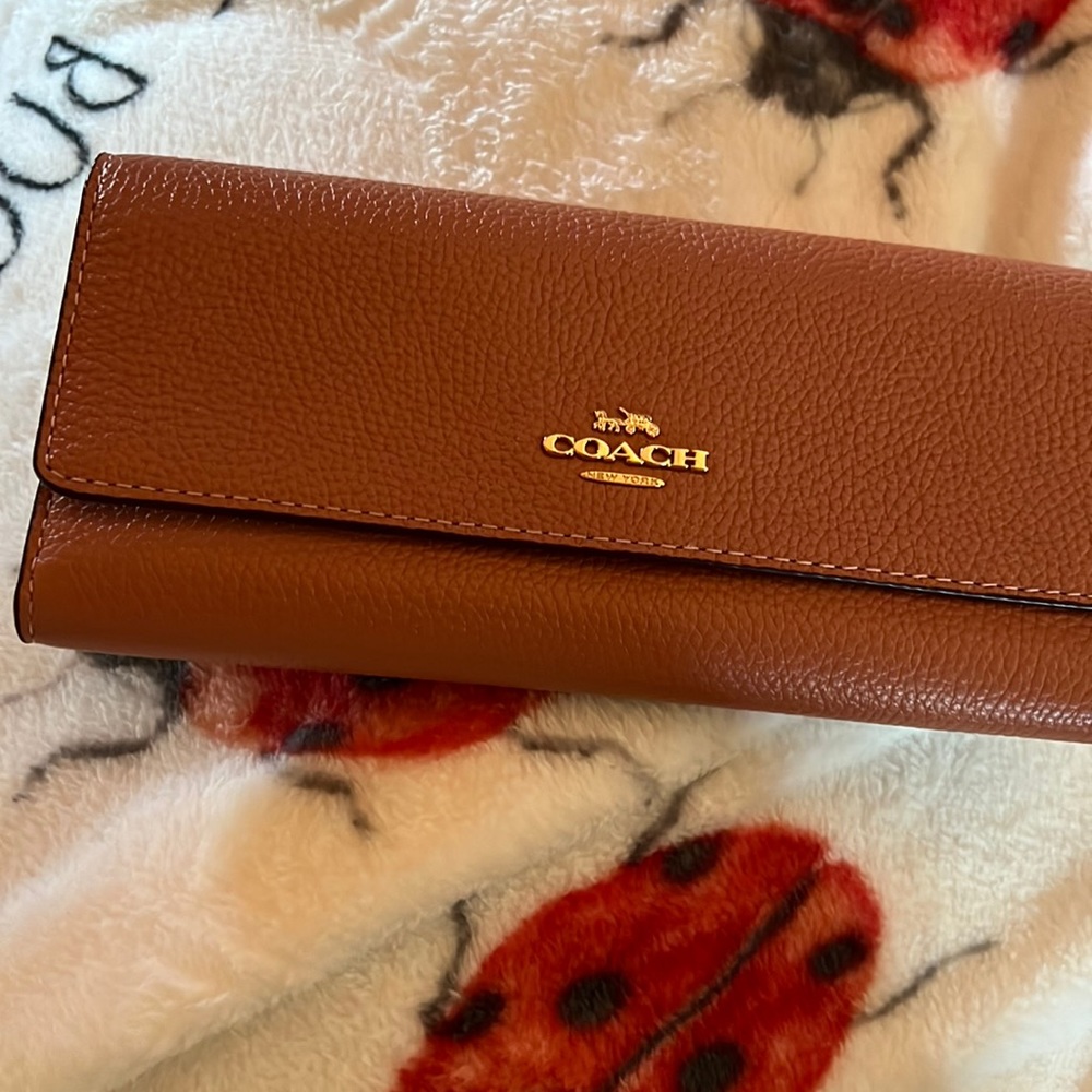 Coach wallet will match the peach satchel coach bag but the symbols is gold